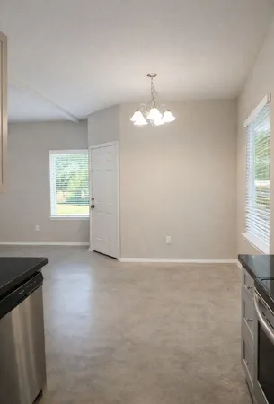 an empty room with windows and chandelier