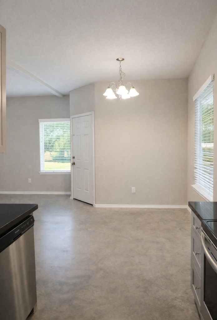 1100 Mann Road Conroe, TX 77303 - Photo 7 of 16 an empty room with windows and chandelier