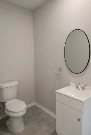 a bathroom with a toilet a sink and mirror