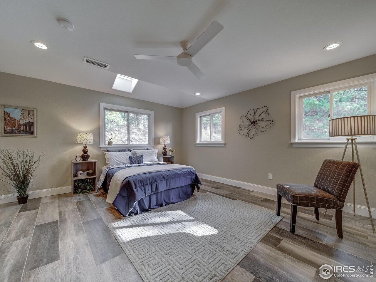 5634 Longmont Dam Road Lyons, CO 80540 - Photo 22 of 34 a spacious bedroom with a bed a couch and a window