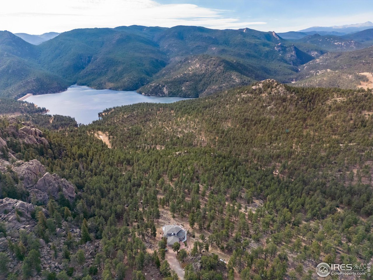 5634 Longmont Dam Road Lyons, CO 80540 - Photo 30 of 34 a view of a house with a mountain and a forest