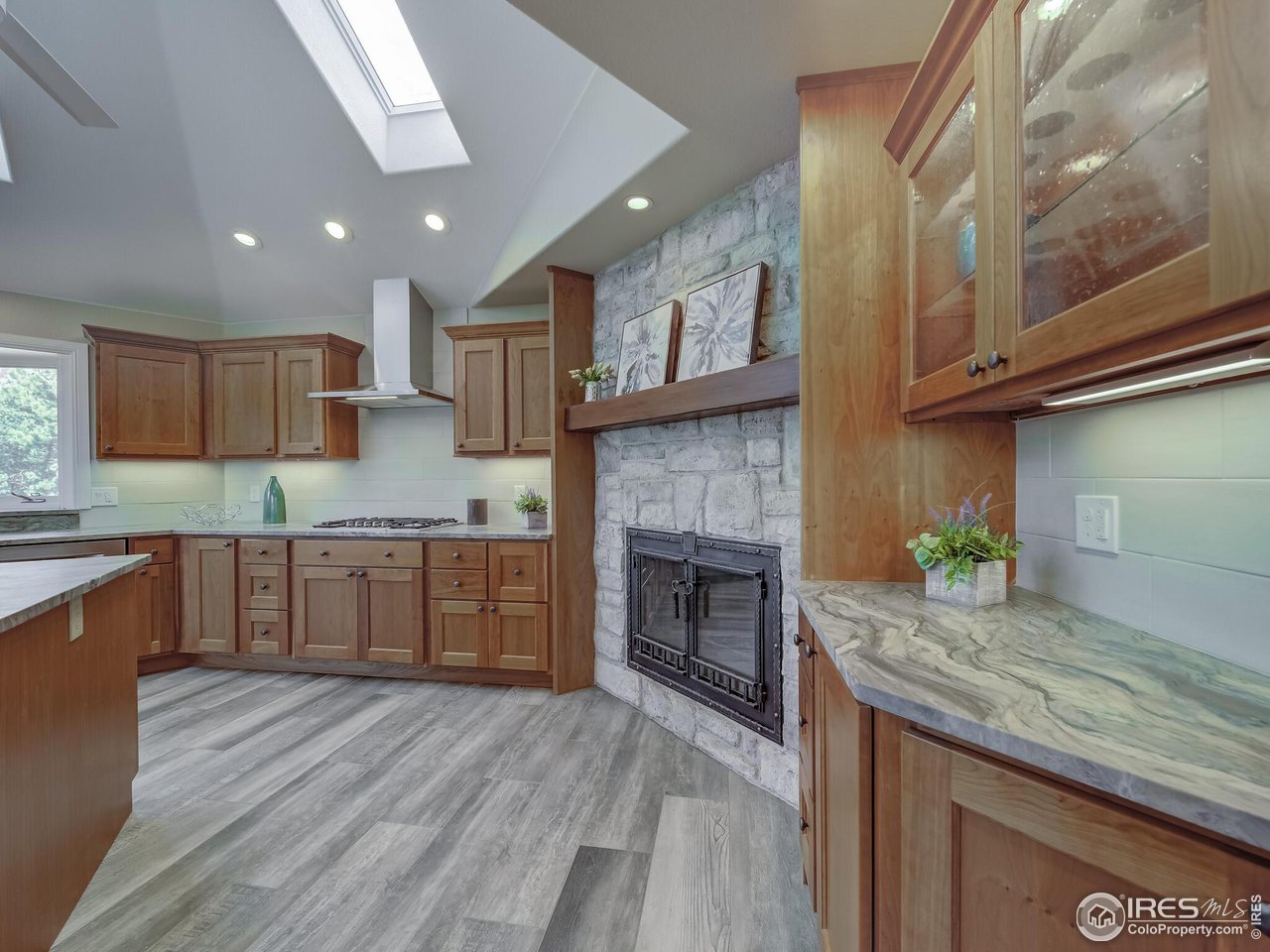 5634 Longmont Dam Road Lyons, CO 80540 - Photo 9 of 34 a kitchen with granite countertop kitchen island wooden floors granite counter tops and a white cabinets