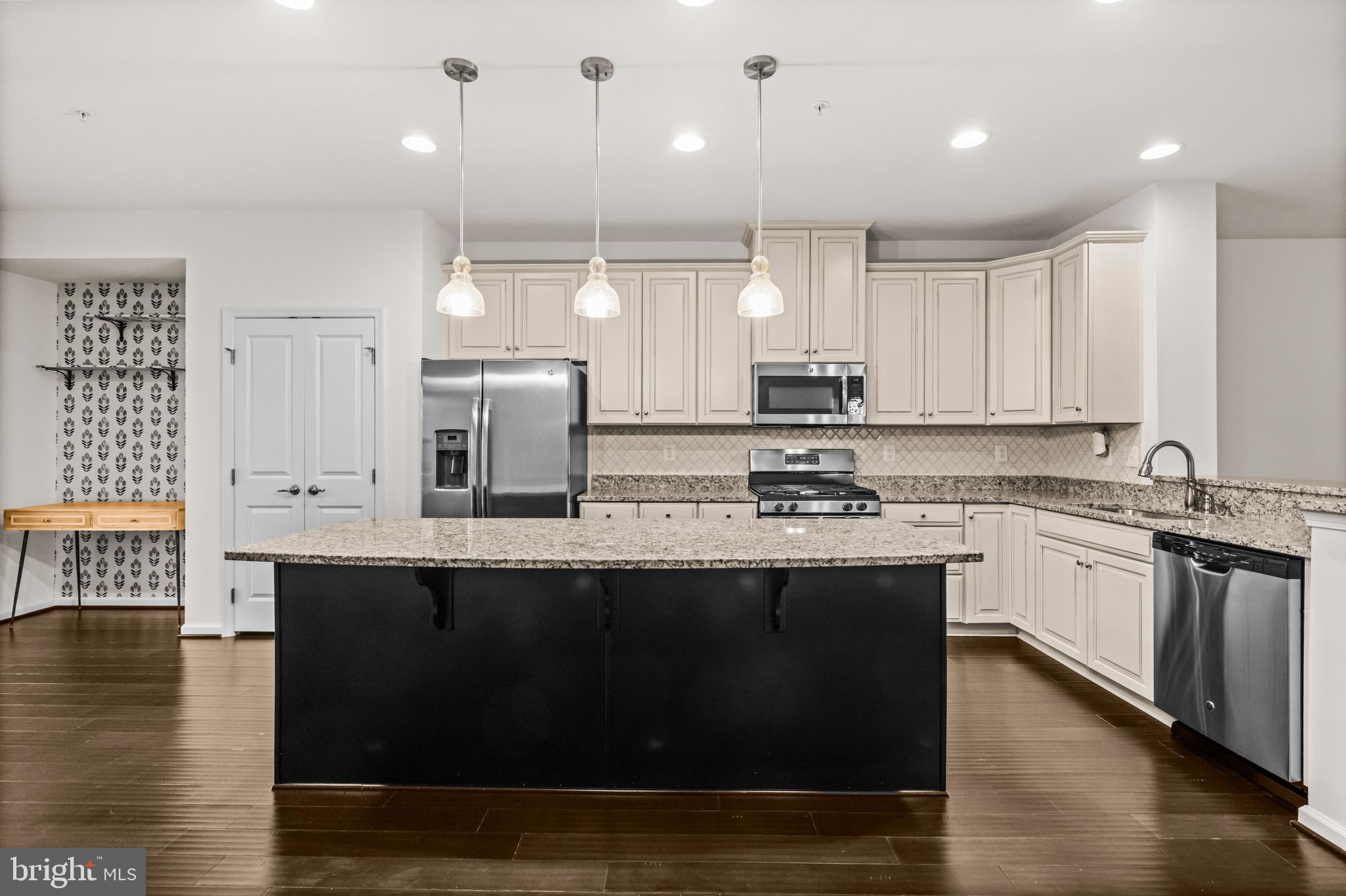 7839 Patterson Way Hanover, MD 21076 - Photo 17 of 56 a kitchen with stainless steel appliances granite countertop a sink a stove and a wooden floors