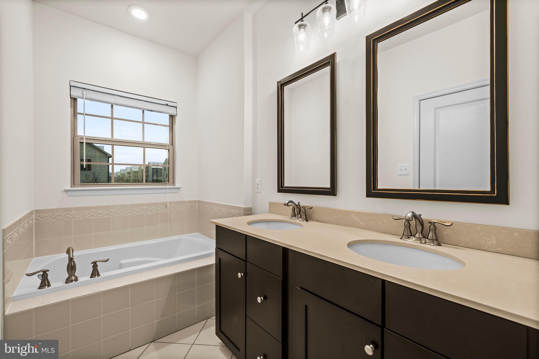 7839 Patterson Way Hanover, MD 21076 - Photo 32 of 56 a bathroom with a tub double sink window and mirror