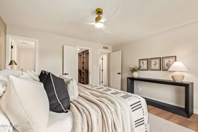 a bedroom with a bed and a lamp on dresser