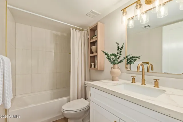 a bathroom with a granite countertop sink a toilet and shower