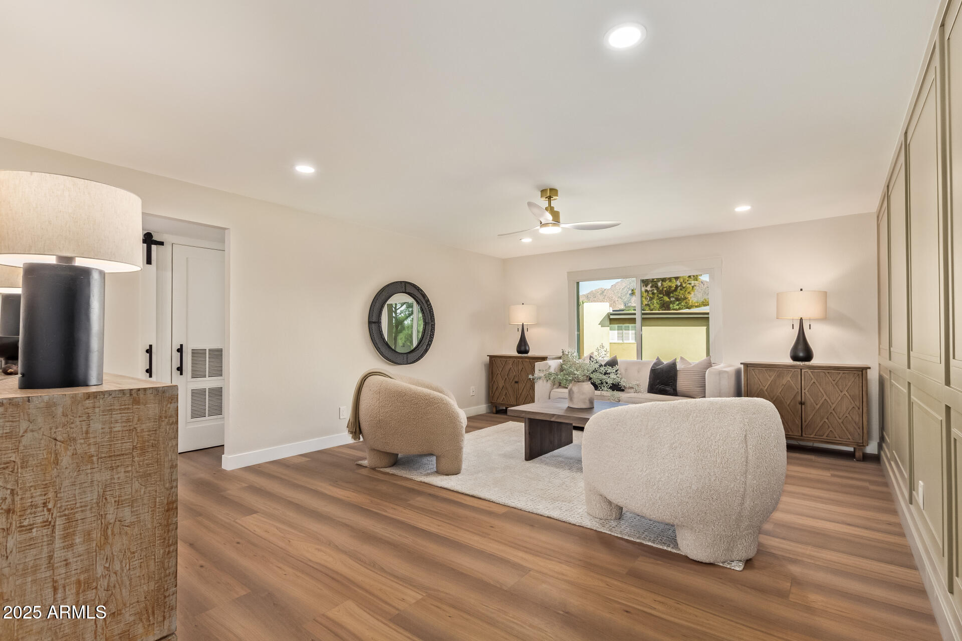 4201 East Camelback Road, Unit 14 Phoenix, AZ 85018 - Photo 2 of 26 a living room with couches a large mirror with wooden floor