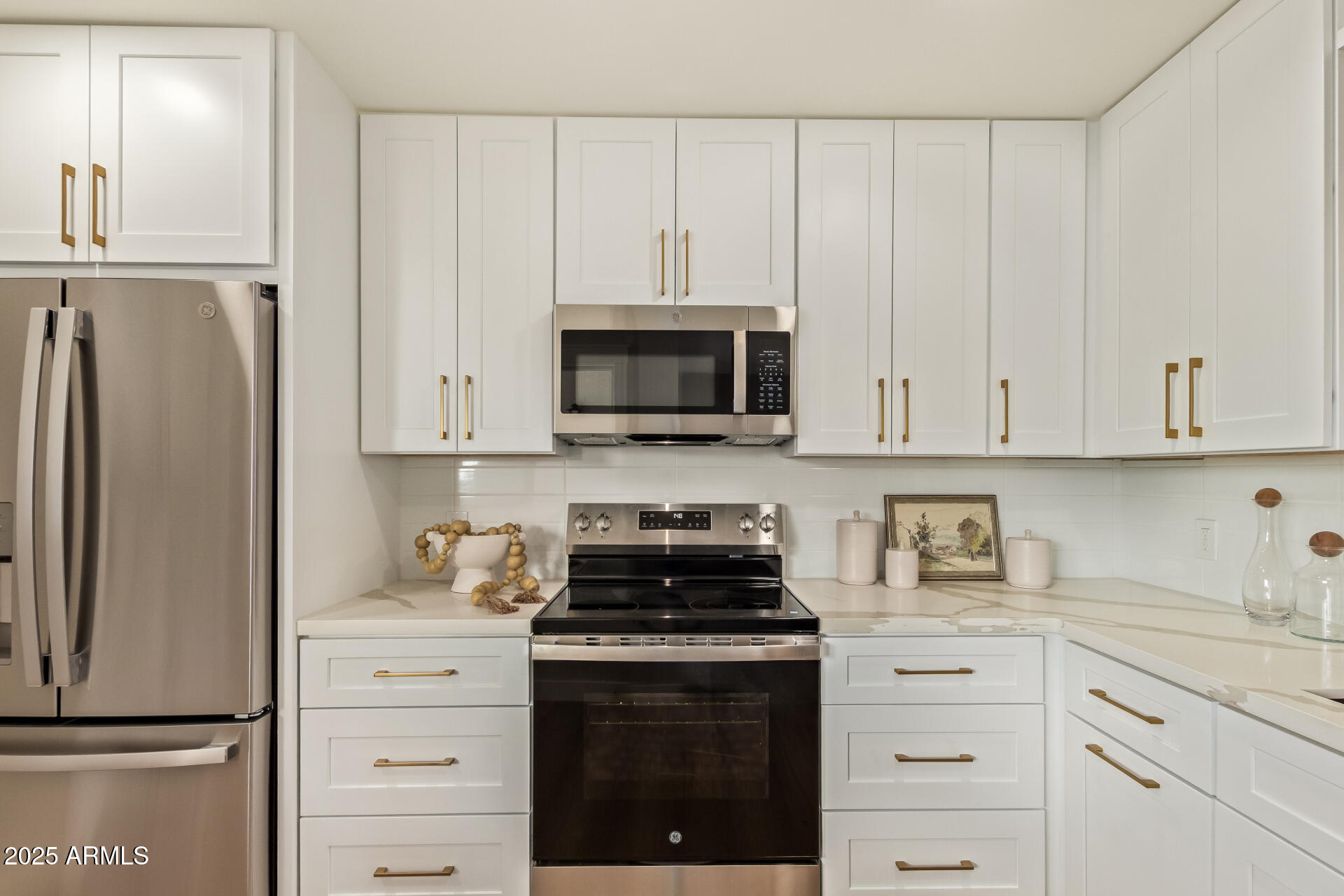 4201 East Camelback Road, Unit 14 Phoenix, AZ 85018 - Photo 9 of 26 a kitchen with white cabinets and stainless steel appliances