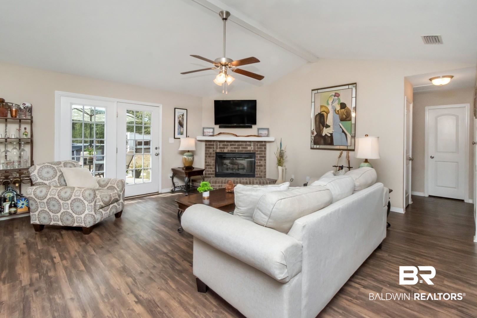 11528 Mocking Bird Lane Fairhope, AL 36532 - Photo 4 of 45 Living area featuring ceiling fan, dark wood-style flooring, beam ceiling, and a fireplace