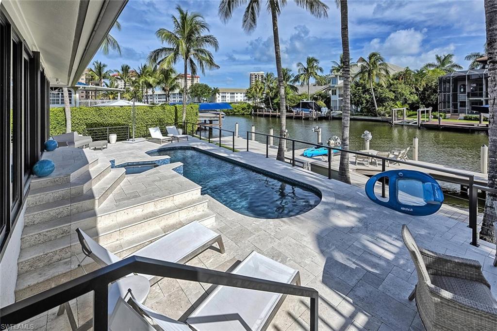 159 Conners Avenue Naples, FL 34108 - Photo 1 of 35 a view of a lake with couches chairs and a table of the ocean