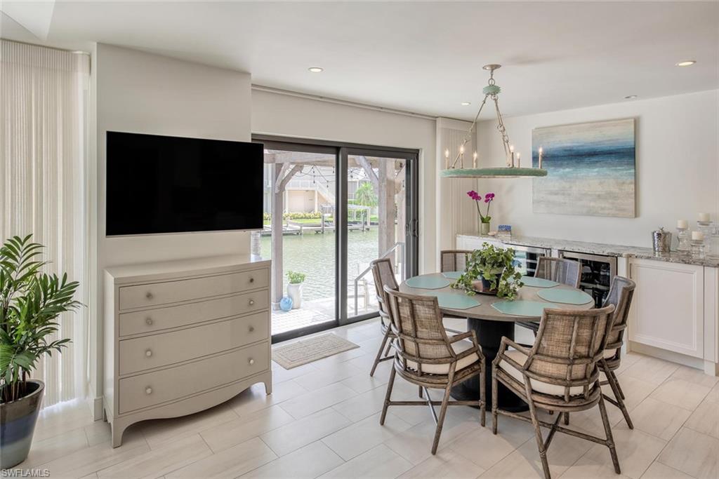 159 Conners Avenue Naples, FL 34108 - Photo 17 of 35 a view of a dining room with furniture and a flat screen tv