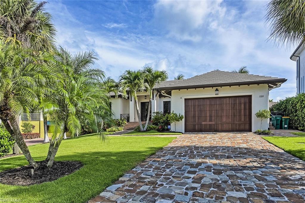 159 Conners Avenue Naples, FL 34108 - Photo 5 of 35 a front view of a house with yard and green space