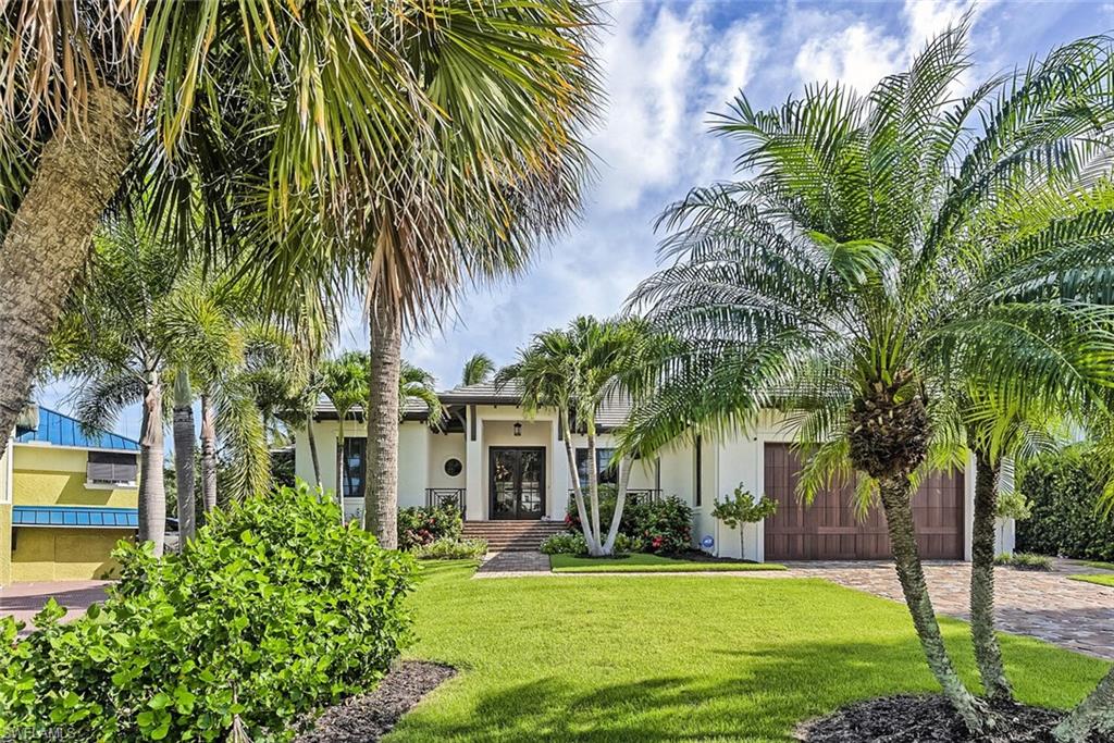 159 Conners Avenue Naples, FL 34108 - Photo 6 of 35 a front view of a house with a garden