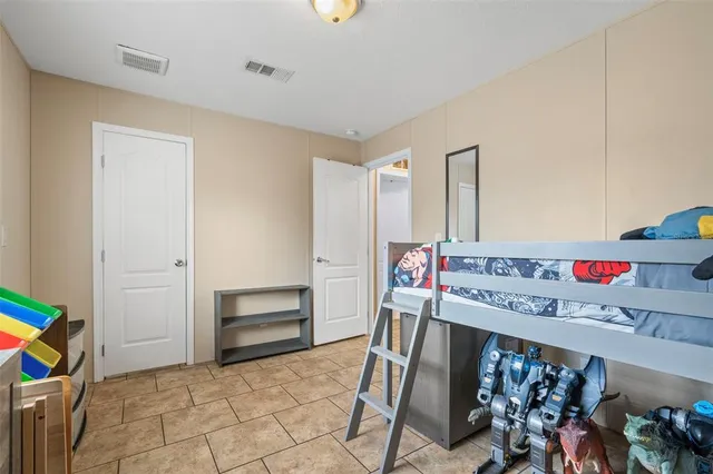 a bedroom with a bed and a flat tv screen on the wall