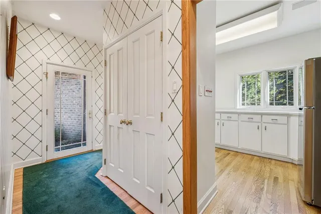 an entryway with wooden floor and cabinet