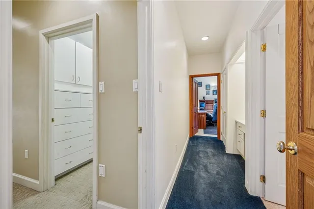 a view of a hallway with wooden floor and closet