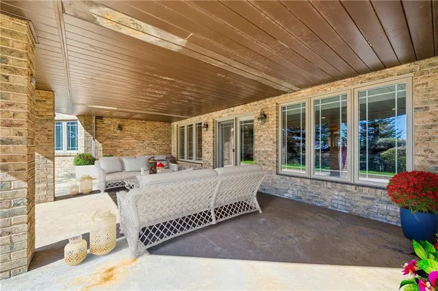 a view of a patio with couches chairs under an umbrella