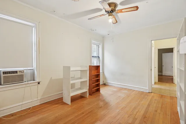 a view of a livingroom with wooden floor and a ceiling fan