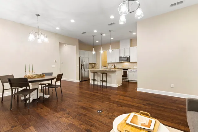 a view of a dining room and livingroom with furniture wooden floor a chandelier
