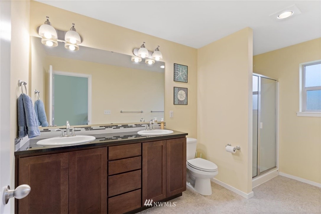111 164th Place Southeast Bothell, WA 98012 - Photo 19 of 27 a bathroom with a granite countertop toilet a sink and a mirror