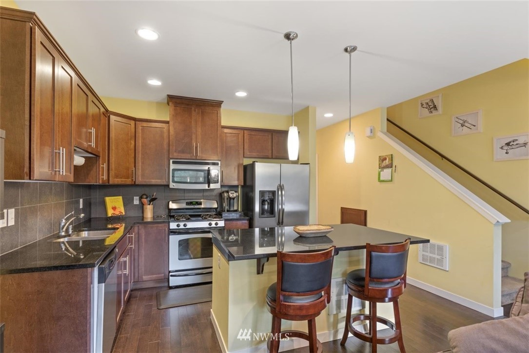 111 164th Place Southeast Bothell, WA 98012 - Photo 5 of 27 a kitchen with stainless steel appliances granite countertop a sink a stove a refrigerator cabinets and chairs