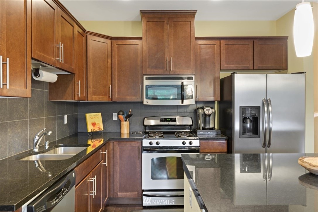 111 164th Place Southeast Bothell, WA 98012 - Photo 6 of 27 a kitchen with kitchen island granite countertop a sink stainless steel appliances and cabinets