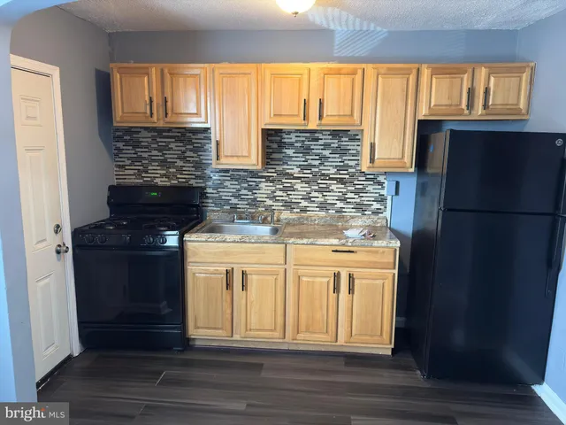 a kitchen with stainless steel appliances granite countertop a refrigerator and a stove