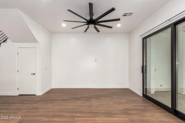 a view of a livingroom with a ceiling fan and wooden floor