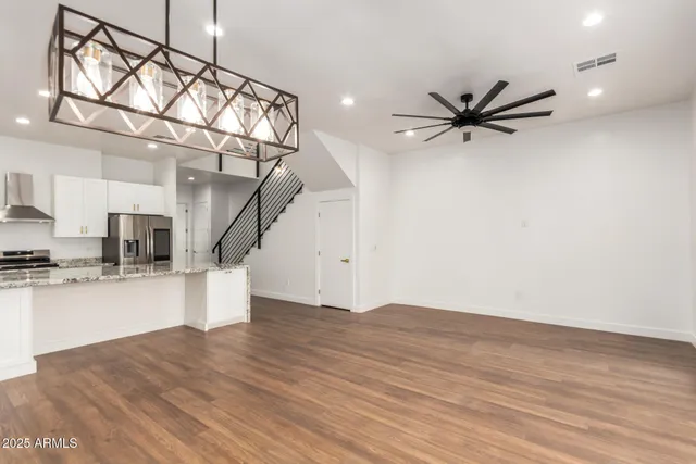 a view of a livingroom with wooden floor and a ceiling fan
