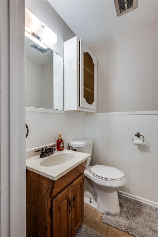 1428 Pamela Street Hurst, TX 76053 - Photo 12 of 25 a bathroom with a sink a toilet and mirror