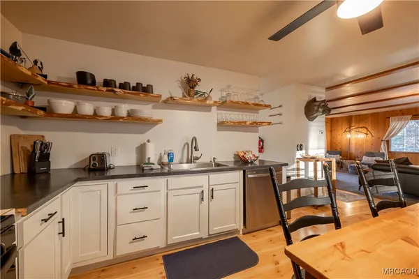 a kitchen with granite countertop lots of white cabinets and chairs