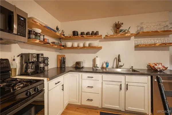 a kitchen with white cabinets and appliances