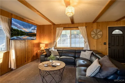 a living room with furniture a flat screen tv and a large window