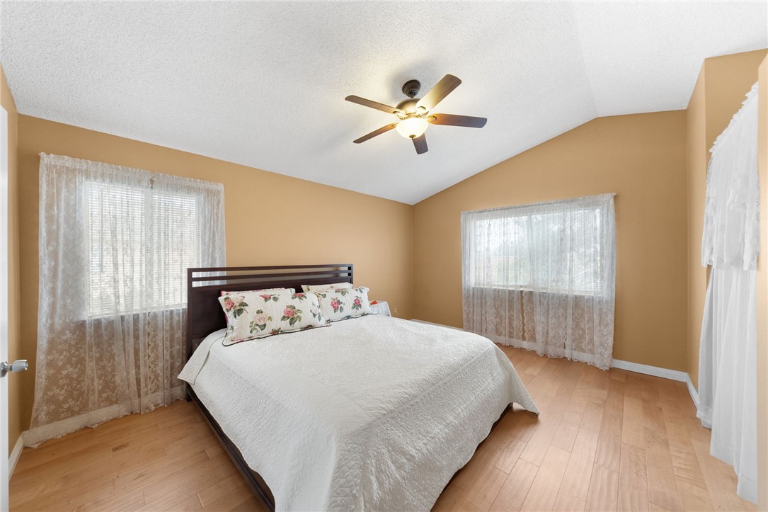19320 Totem Court Riverside, CA 92508 - Photo 24 of 53 Light-filled bedroom with vaulted ceiling, ceiling fan, and multiple windows for a bright, comfortable space.