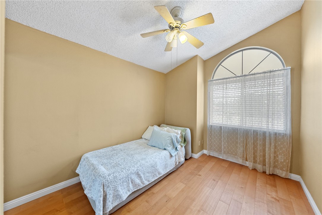 19320 Totem Court Riverside, CA 92508 - Photo 28 of 53 Light-filled bedroom with vaulted ceiling, ceiling fan, and large arched window for added character.