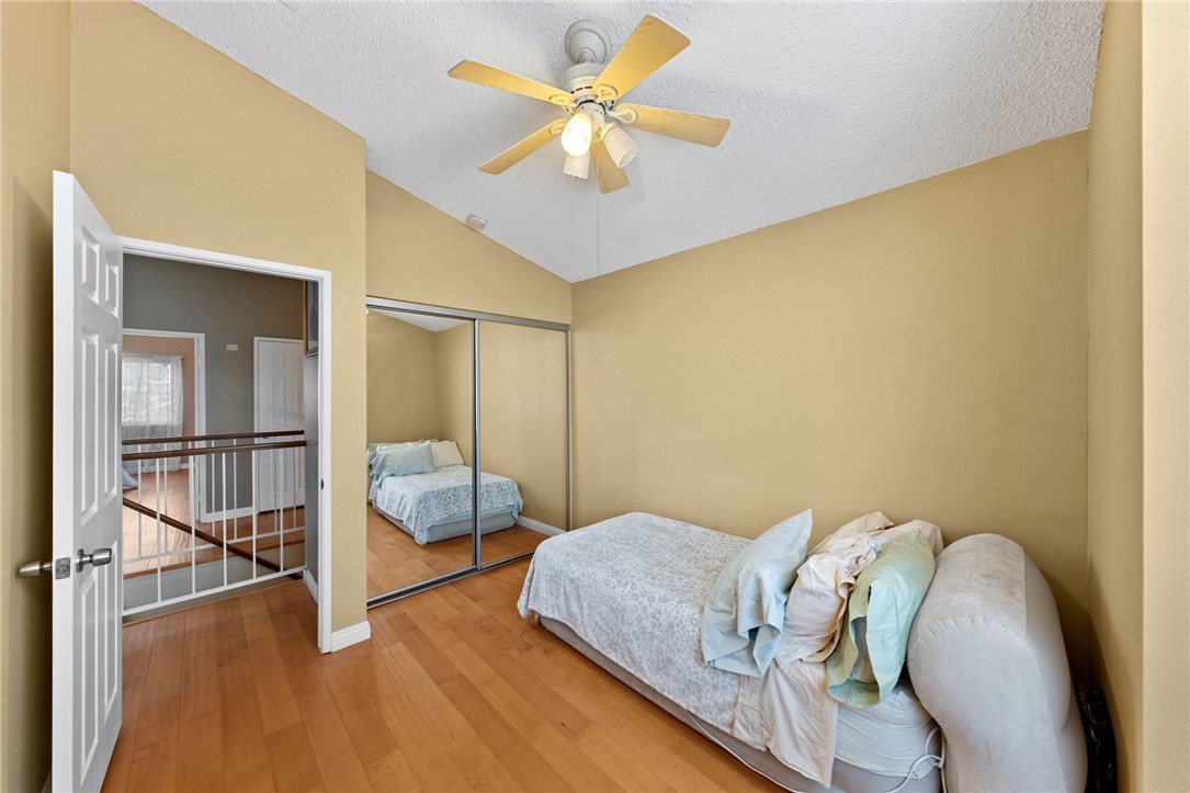 19320 Totem Court Riverside, CA 92508 - Photo 29 of 53 Bedroom with mirrored closet doors, ceiling fan, and hardwood flooring with open hallway access.