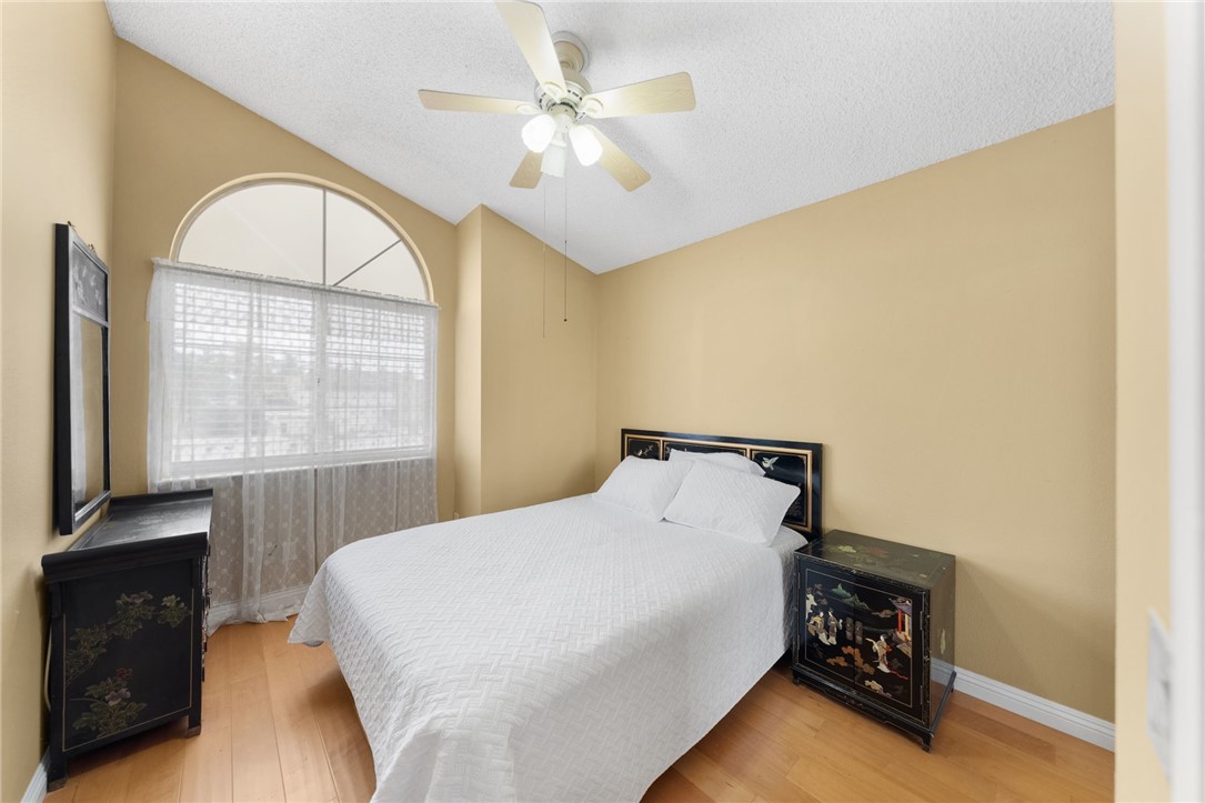 19320 Totem Court Riverside, CA 92508 - Photo 30 of 53 Cozy bedroom with vaulted ceiling, ceiling fan, arched window, and classic built-in style nightstands/dresser.