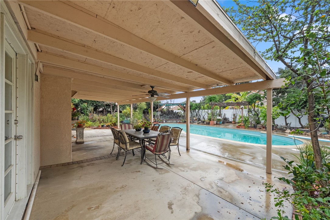19320 Totem Court Riverside, CA 92508 - Photo 33 of 53 Covered patio area with dining set overlooking the pool—ideal for outdoor meals and lounging.