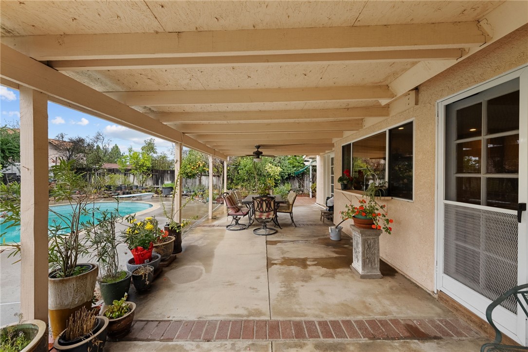 19320 Totem Court Riverside, CA 92508 - Photo 41 of 53 Covered patio corridor with seating and potted plants, offering shaded outdoor living beside the pool.