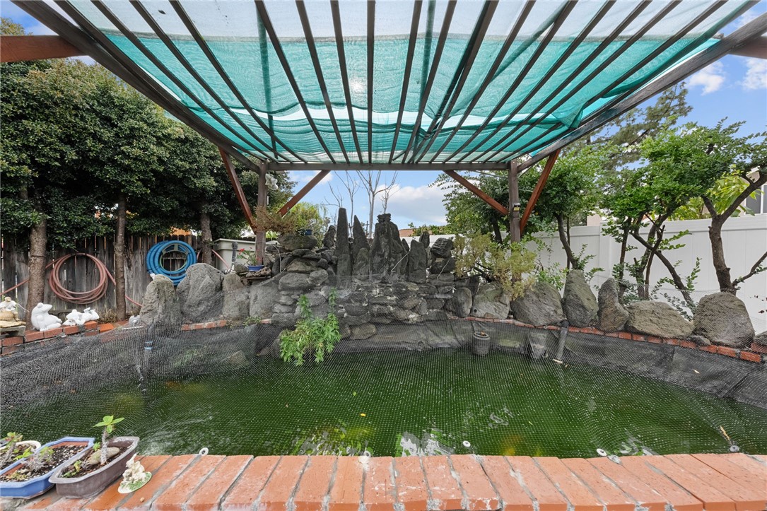 19320 Totem Court Riverside, CA 92508 - Photo 43 of 53 Backyard koi pond with rock landscaping and shade structure overhead—great as a tranquil garden focal point.