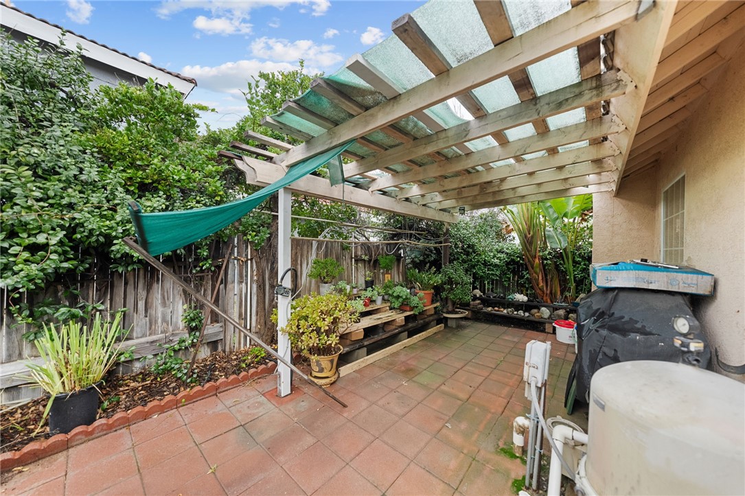 19320 Totem Court Riverside, CA 92508 - Photo 50 of 53 Sheltered patio area with paver flooring and space for storage/workbench/potting, offering functional outdoor flex space.