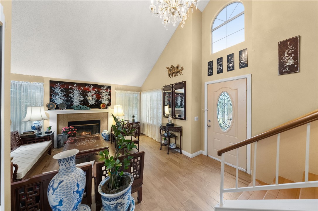 19320 Totem Court Riverside, CA 92508 - Photo 7 of 53 Dramatic vaulted ceilings and an arched window create an airy first impression, with a cozy fireplace as a focal point.