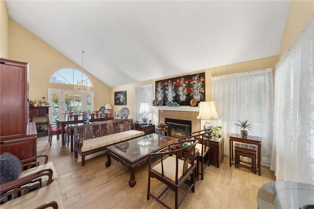 19320 Totem Court Riverside, CA 92508 - Photo 8 of 53 Spacious gathering area with vaulted ceiling, abundant natural light, and fireplace—ideal for relaxing or entertaining.