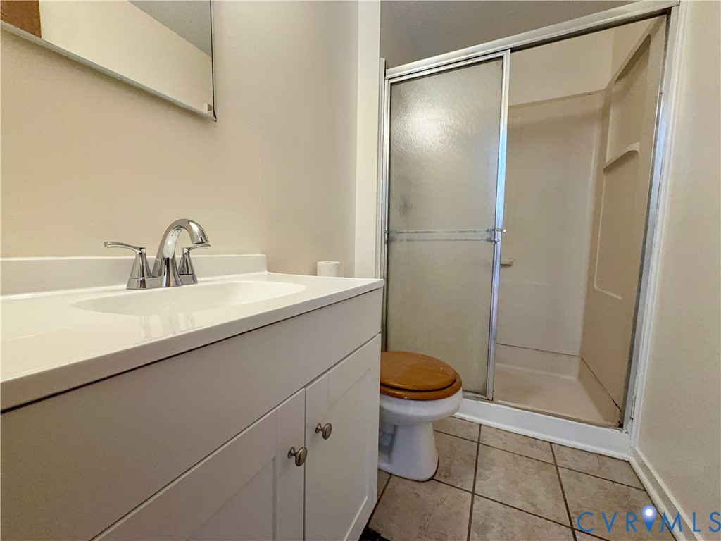 3901 Old Warwick Road Richmond, VA 23234 - Photo 16 of 21 Full bathroom with vanity, a shower stall, and lig