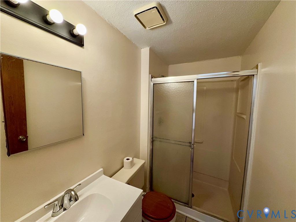 3901 Old Warwick Road Richmond, VA 23234 - Photo 17 of 21 Full bath with a shower stall, a textured ceiling,