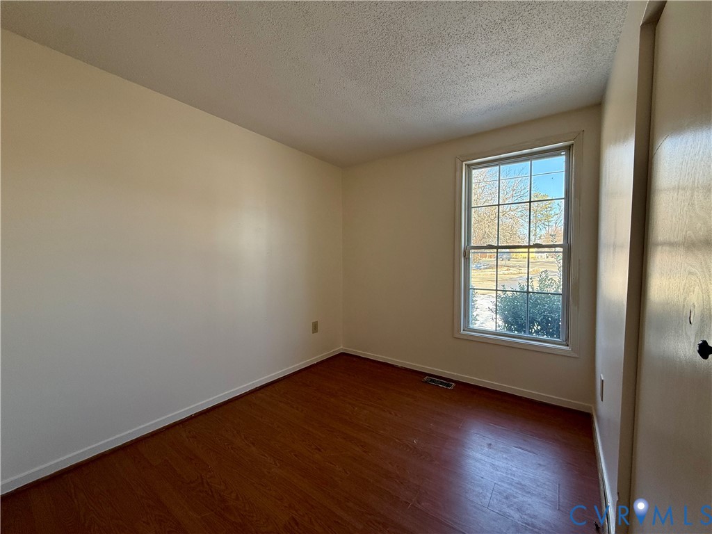 3901 Old Warwick Road Richmond, VA 23234 - Photo 10 of 21 Empty room with dark wood finished floors and a te
