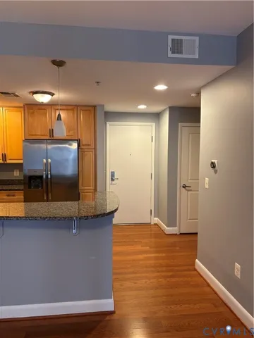 a view of a hallway with stainless steel appliances