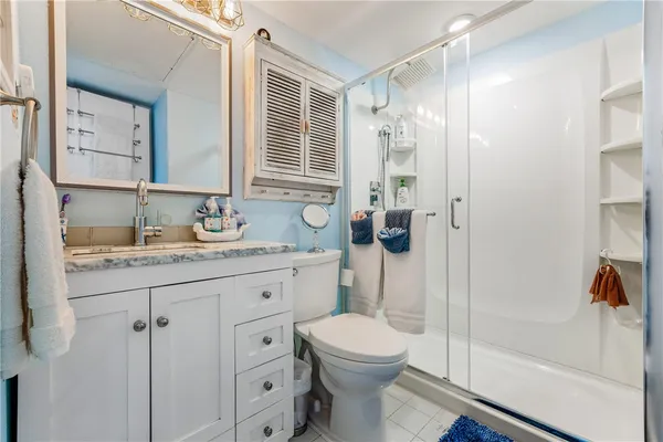 a bathroom with a granite countertop sink toilet and shower