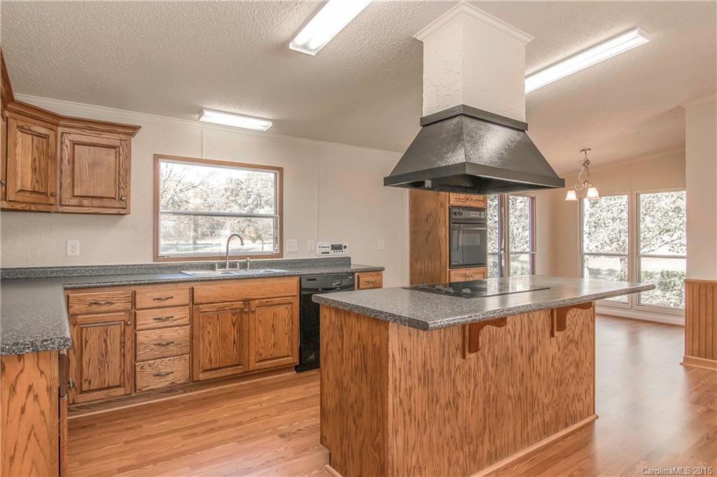 1815 Crowder Road Monroe, NC 28112 - Photo 4 of 24 a kitchen with stainless steel appliances granite countertop a stove a sink and a wooden cabinets