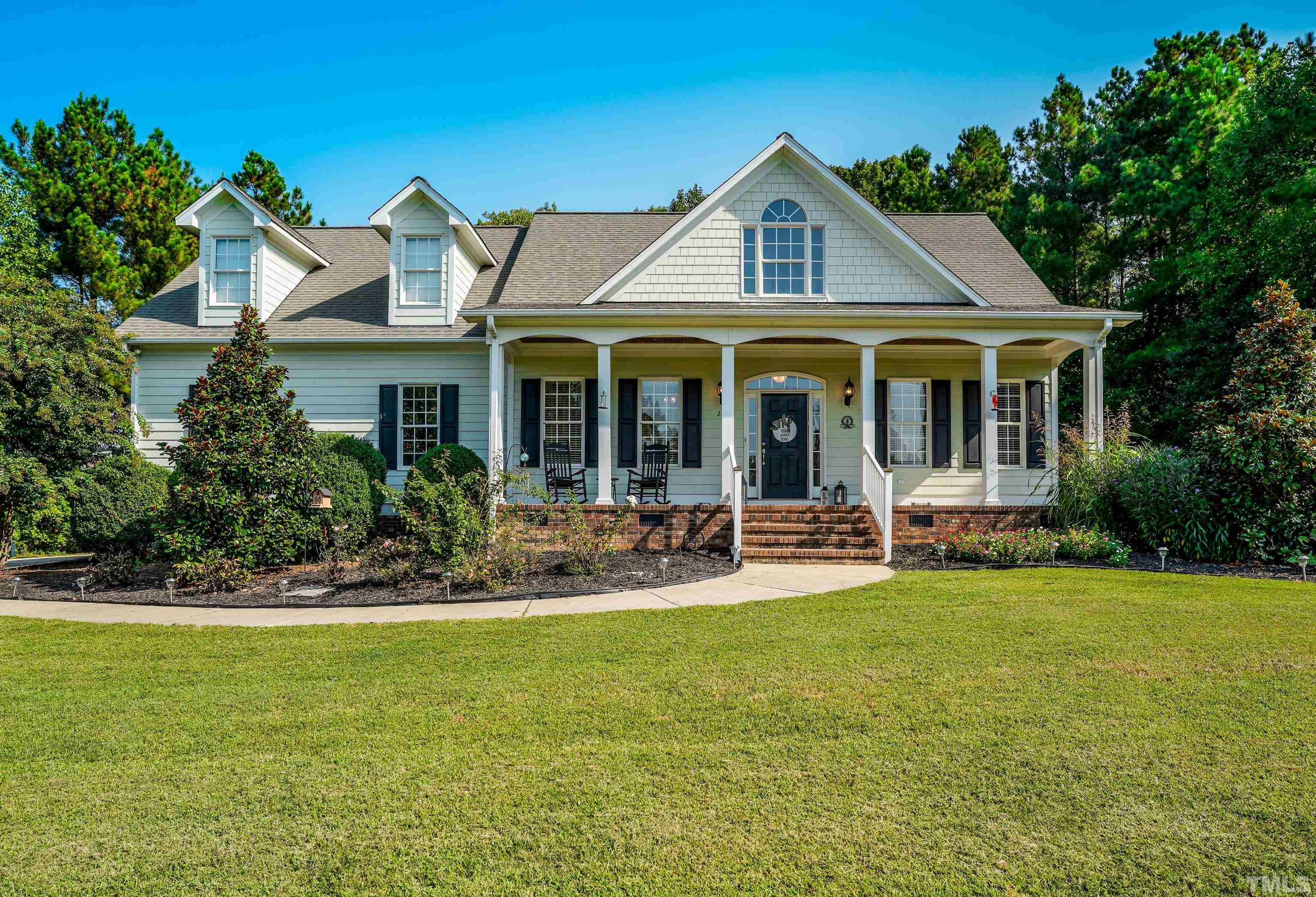 a front view of a house with swimming pool and porch